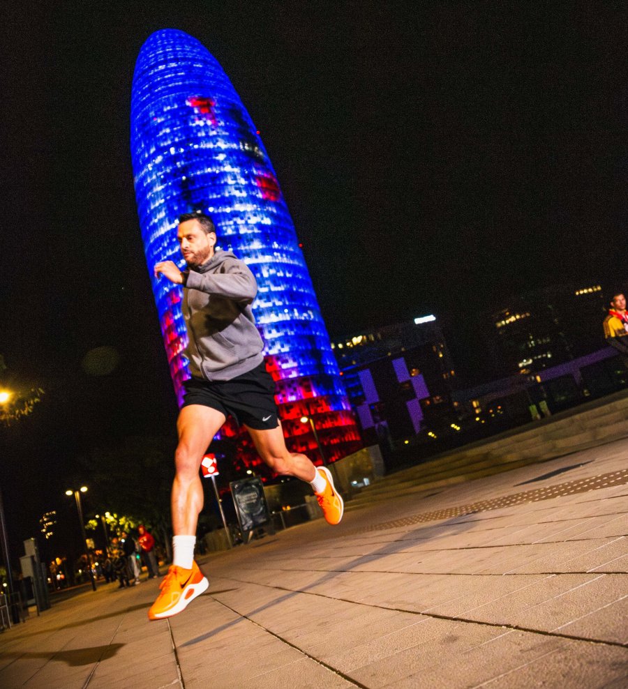 Carlos corriendo de noche frente a la Torre Glòries de Barcelona durante un entrenamiento del Sprinter Run Club