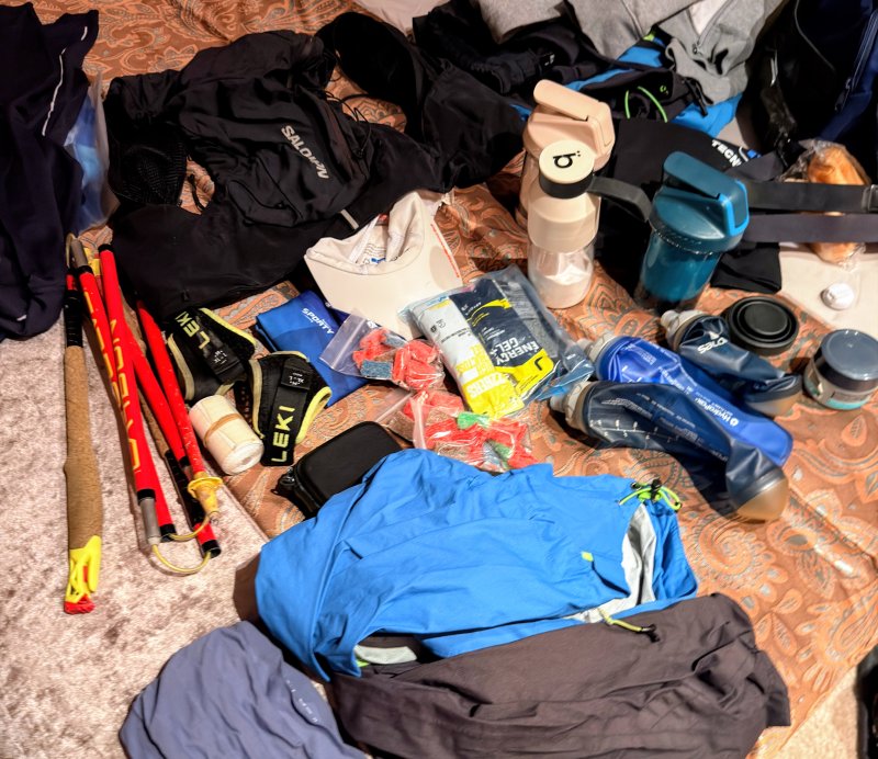 Material de carrera de trail preparado con geles, flasks de bebida y bastones